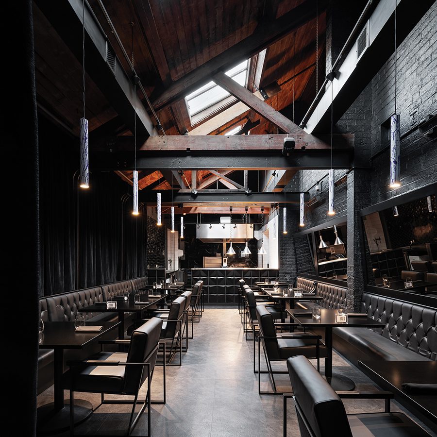 The interior of The Wilderness, Birmingham with black booth seating and a vaulted ceiling